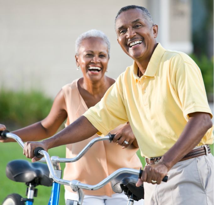middle aged couple walking with bikes