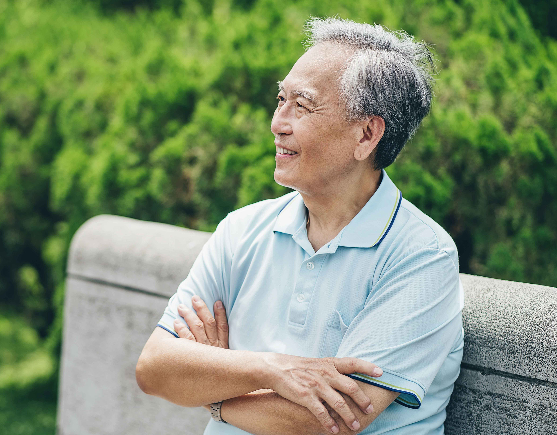 A man smiling on a bench.