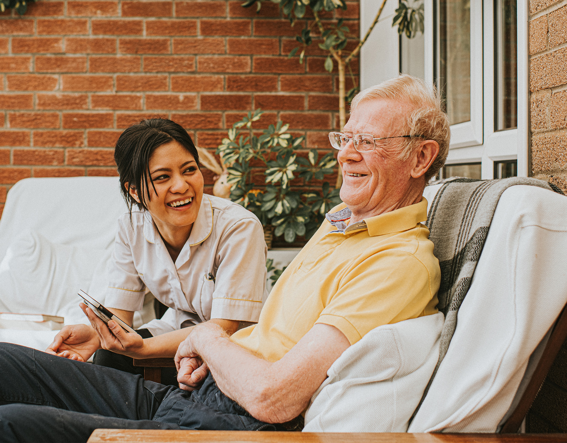 Two people sitting outside talking.