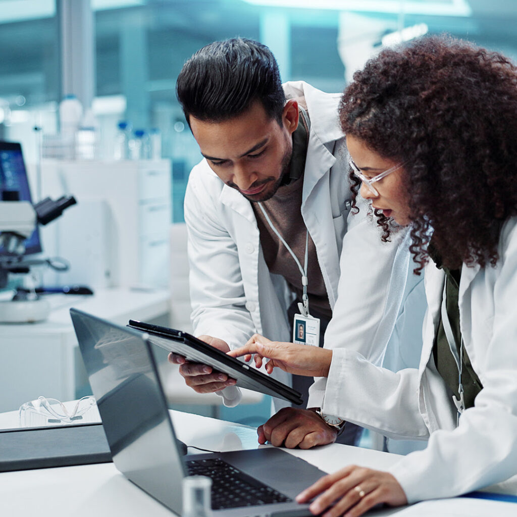 Image of two clinicians in a lab looking at a tablet device.